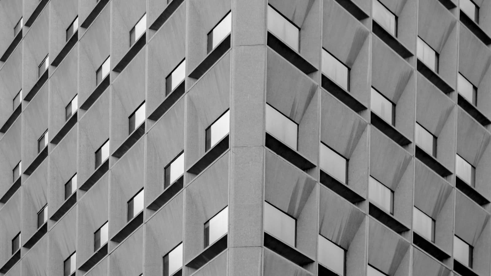 Tight crop on the corner of a grid-window office tower with regular geometric repetition.