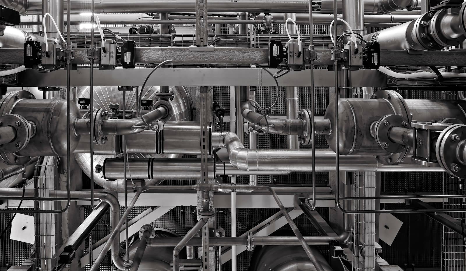 Stainless steel process vessels and piping in an industrial production facility.